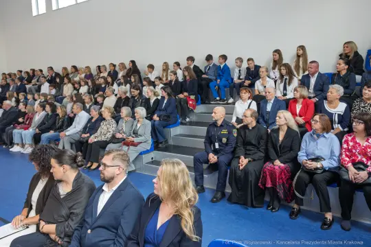 Grupa ludzi siedzących na widowni podczas wydarzenia.