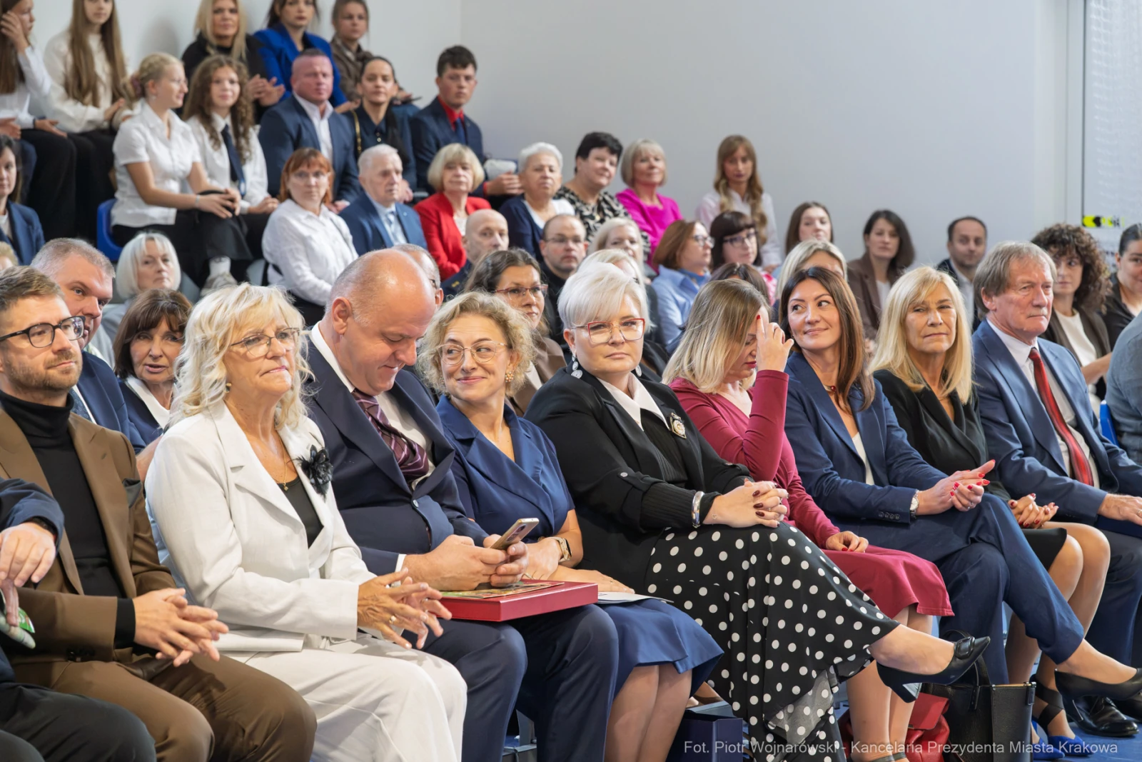 Grupa ludzi siedzących na widowni podczas wydarzenia, wśród nich kilka kobiet w eleganckich strojach.  Autor: Piotr Wojnarowski