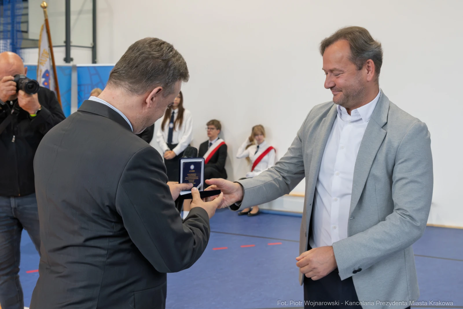 Wręczenie medalu podczas uroczystości w sali sportowej.  Autor: Piotr Wojnarowski