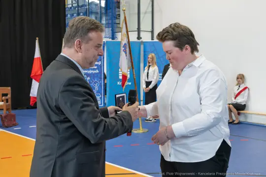 Wręczenie nagrody podczas ceremonii w hali sportowej.