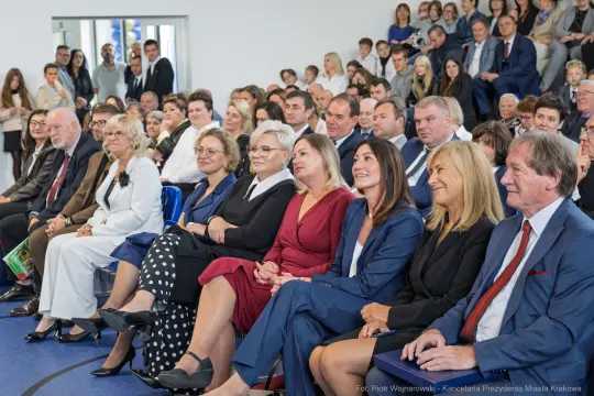 Grupa ludzi siedzących na widowni podczas wydarzenia.