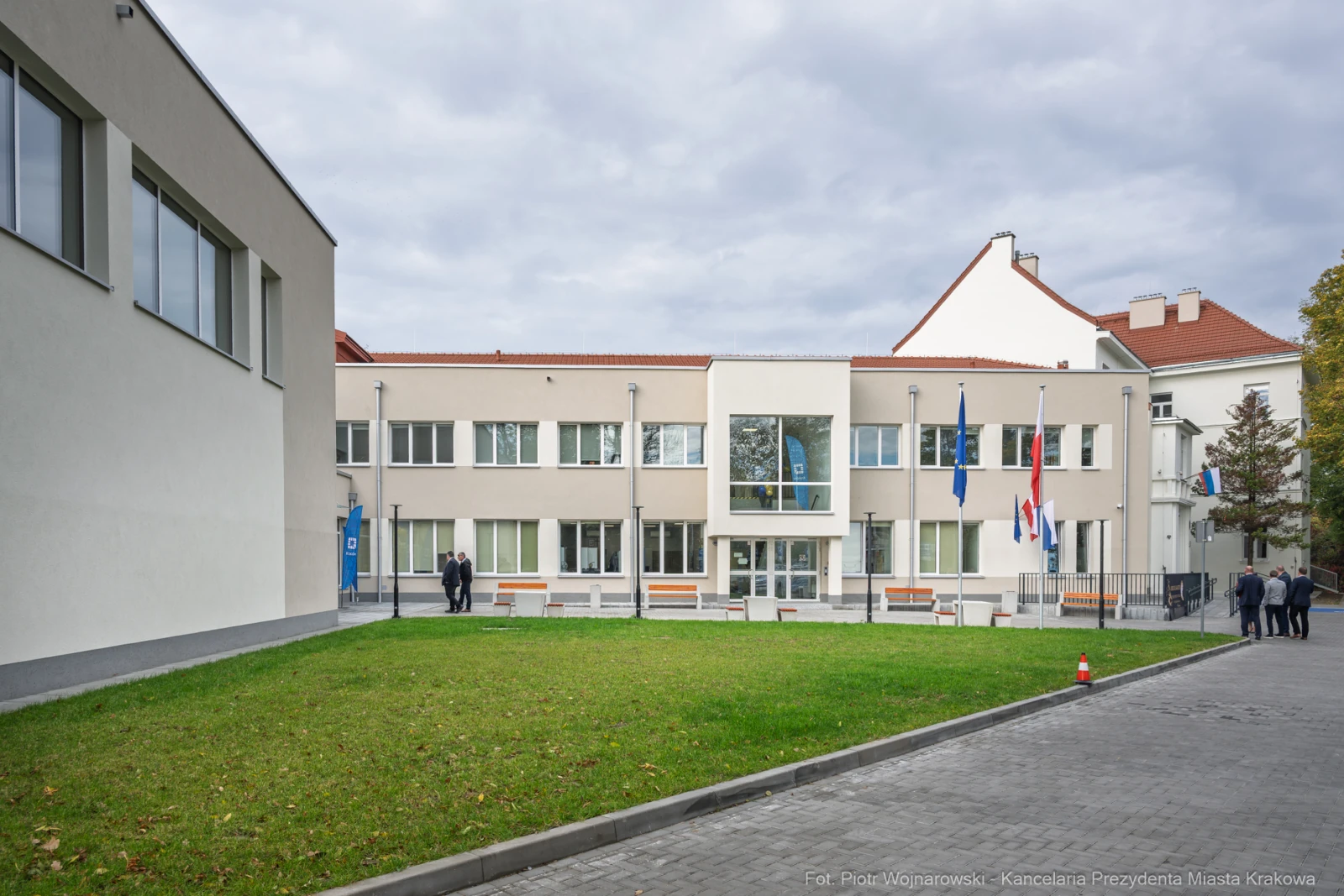Budynek urzędowy z flagami, otoczony trawnikiem i chodnikiem.  Autor: Piotr Wojnarowski