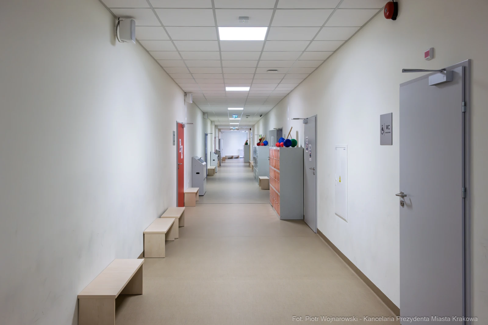 Korytarz z jasnymi ścianami, ławkami i szafkami po obu stronach.  Autor: Piotr Wojnarowski