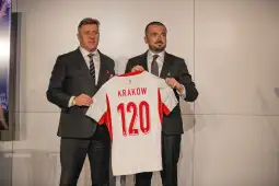 Dwaj mężczyźni trzymają koszulkę piłkarską z napisem Kraków i numerem 120.
