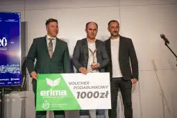 Trzej mężczyźni trzymający voucher podarunkowy oraz statuetkę.