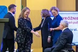Uroczystość wręczenia nagród publicznych, uściski dłoni i gratulacje.