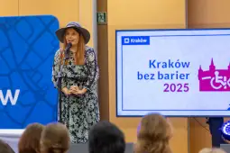 Kobieta w kapeluszu przemawia na scenie podczas wydarzenia Kraków bez barier 2025.