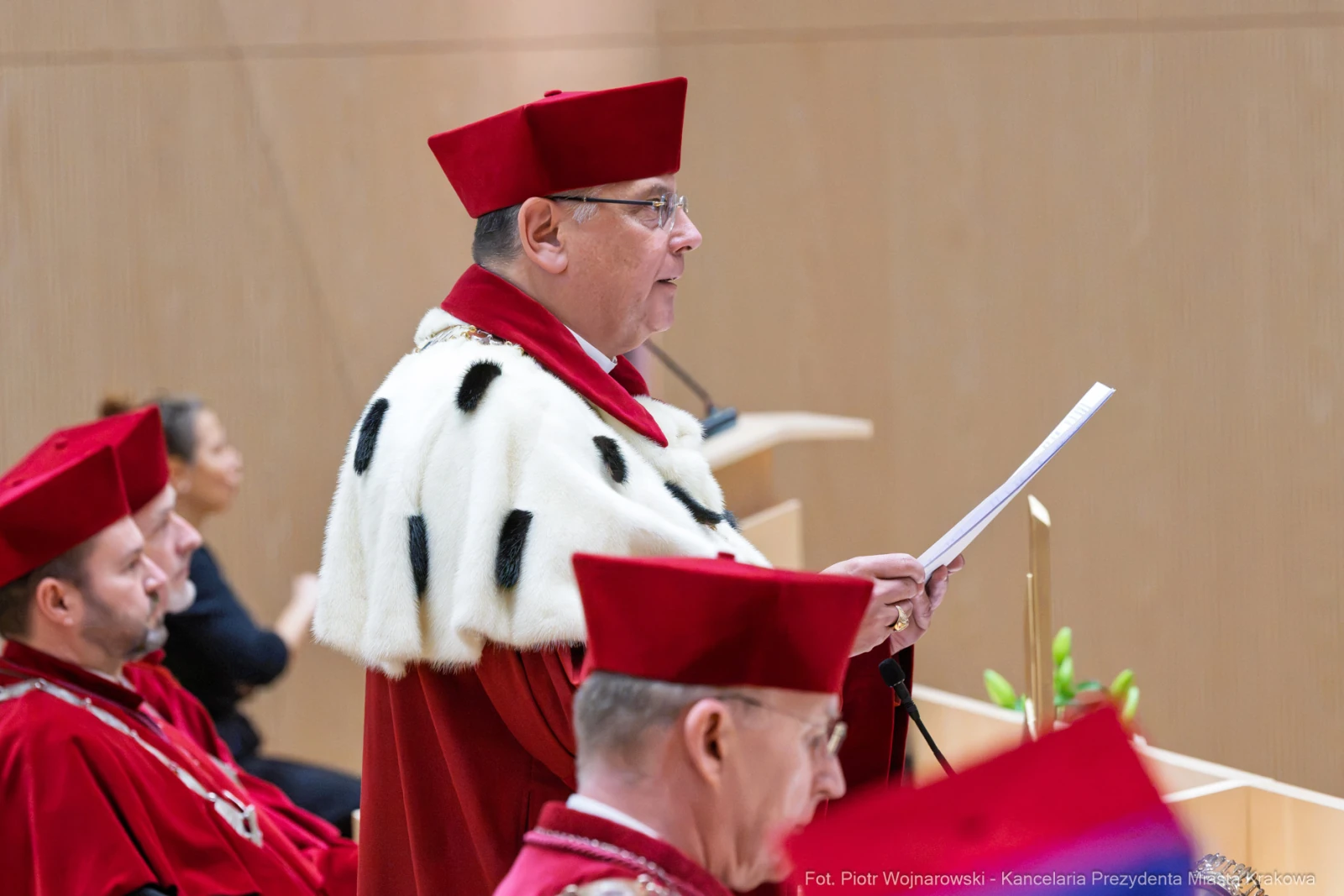 Mężczyzna w czerwonym stroju akademickim wygłasza przemówienie.  Autor: Piotr Wojnarowski