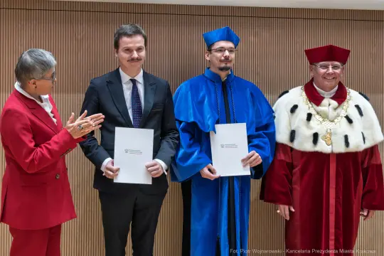 Ceremonia wręczenia dokumentów przez urzędników w tradycyjnych strojach.