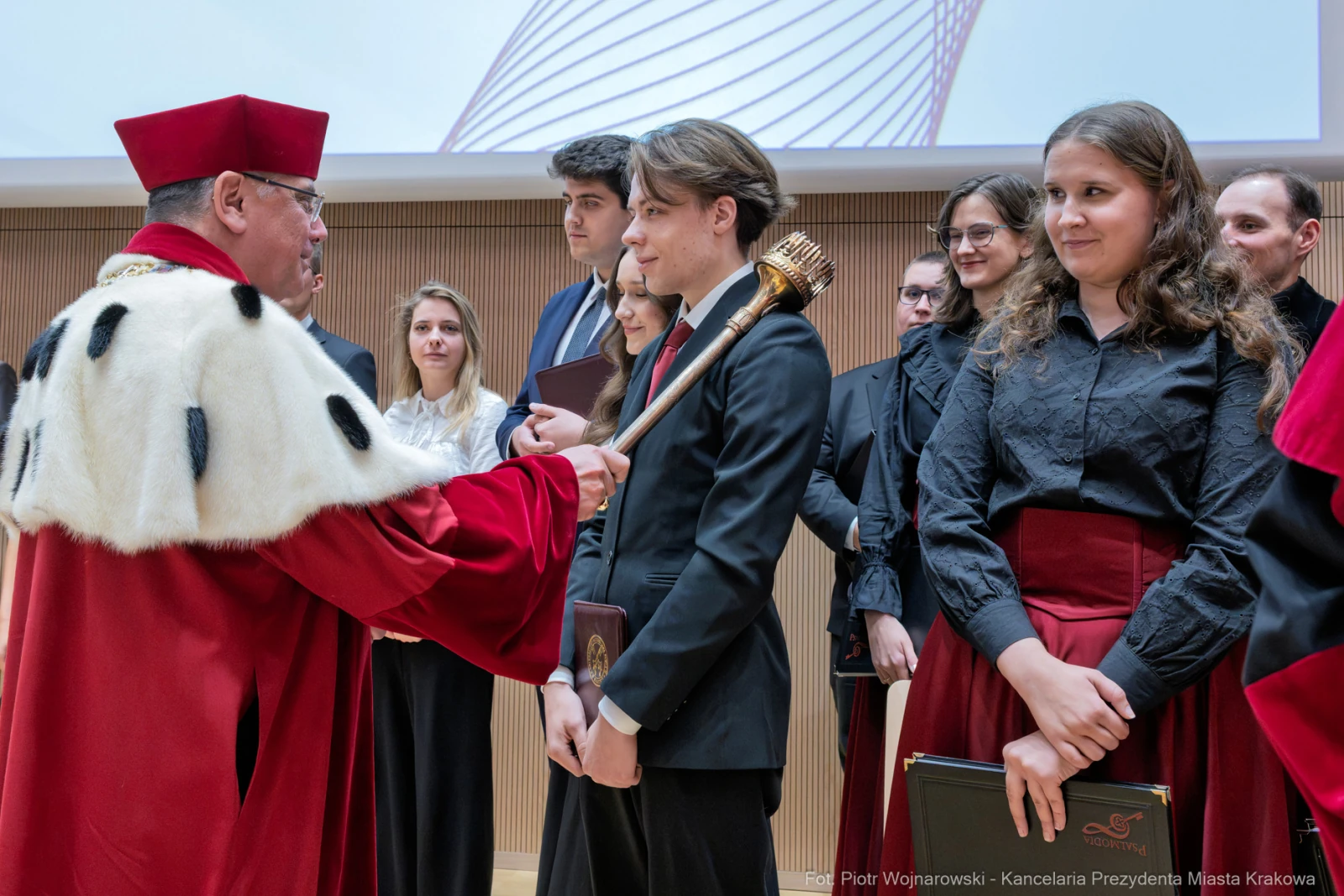 Ceremonia wręczenia dyplomów z udziałem rektora i absolwentów w akademickim otoczeniu.  Autor: Piotr Wojnarowski