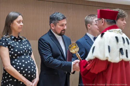 Ceremonia wręczenia nagród z udziałem osób w formalnych strojach.