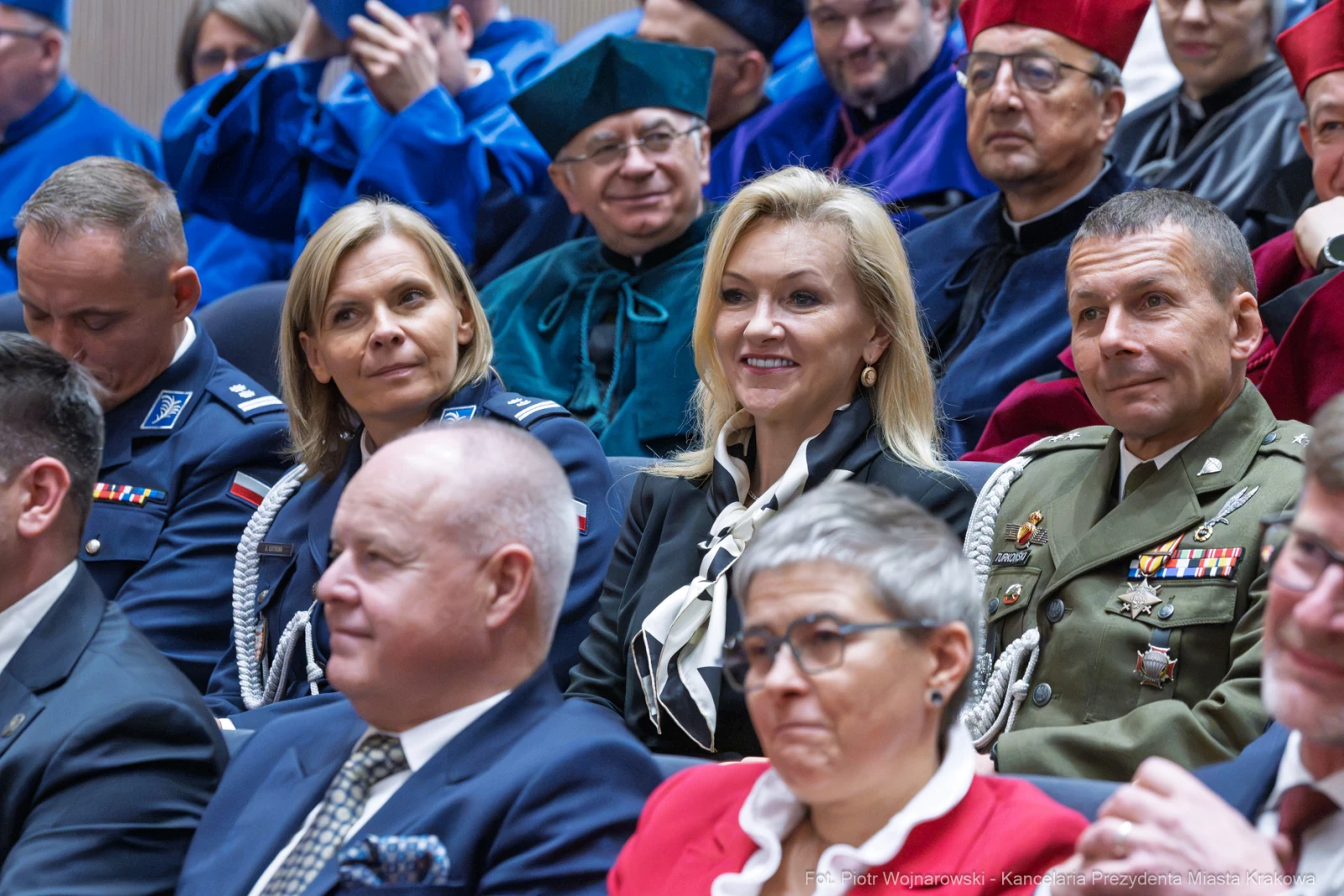 Uczestnicy ceremonii w akademickich togach, wśród nich kobiety i mężczyźni w mundurach.  Autor: Piotr Wojnarowski