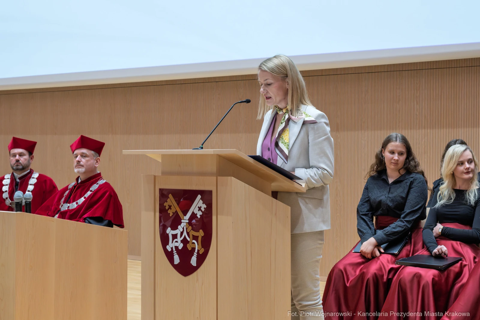 Kobieta przemawia z podium, obok niej siedzą osoby w akademickich togach.  Autor: Piotr Wojnarowski