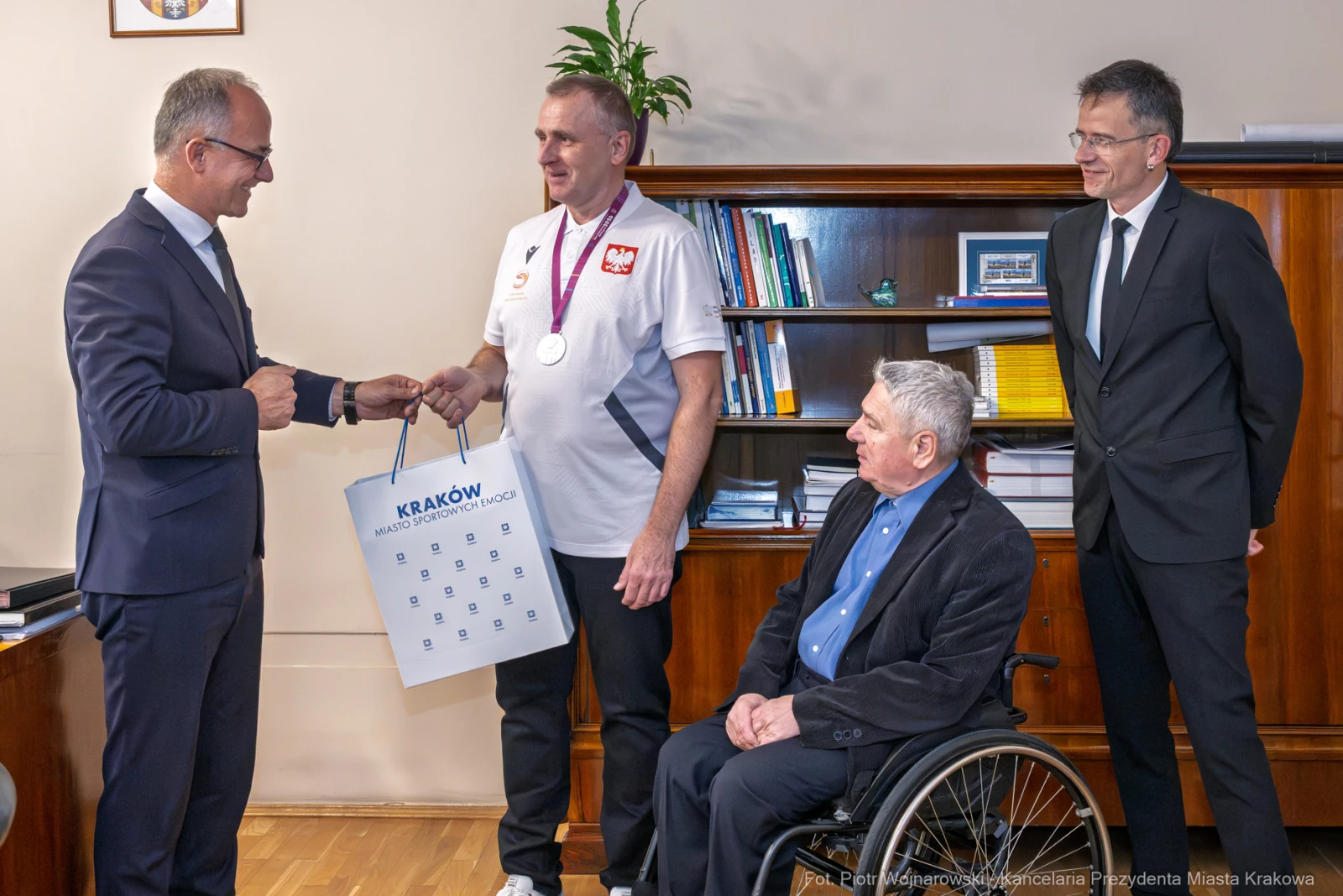 Wręczenie kalendarza przez prezydenta Krakowa medalistowi paraolimpijskiemu.  Autor: Piotr Wojnarowski