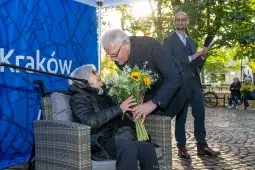 Uroczystość wręczenia kwiatów starszej kobiecie w Krakowie.