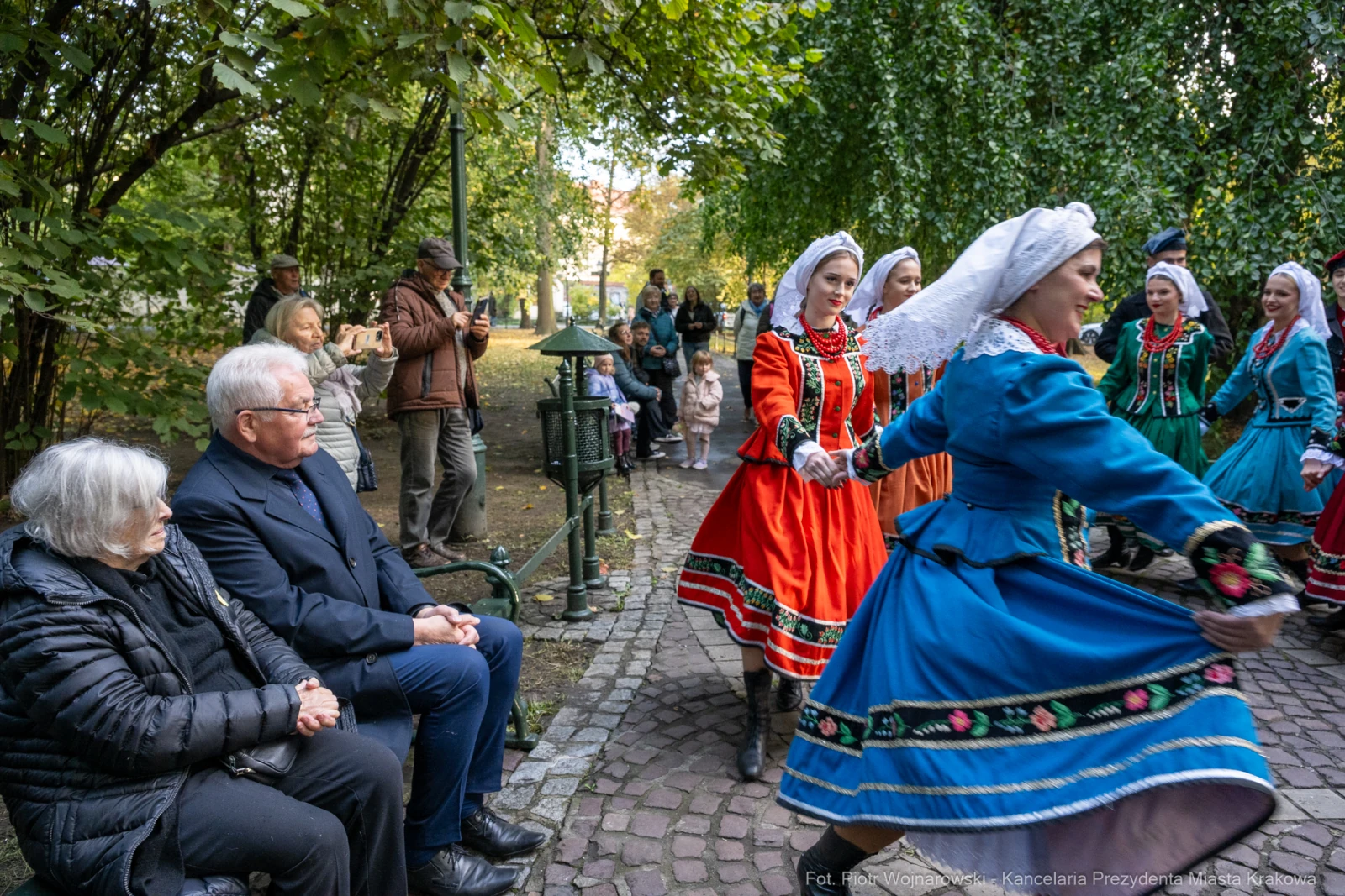 Tradycyjny taniec w kolorowych strojach ludowych, widownia obserwująca występ.  Autor: Piotr Wojnarowski