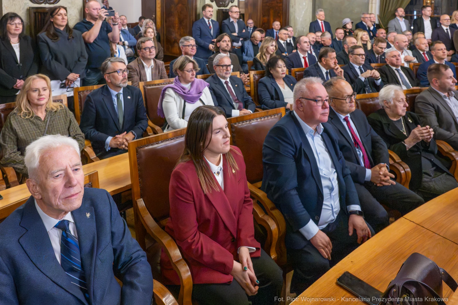 Grupa ludzi w formalnych strojach siedzących w sali obrad.  Autor: Piotr Wojnarowski