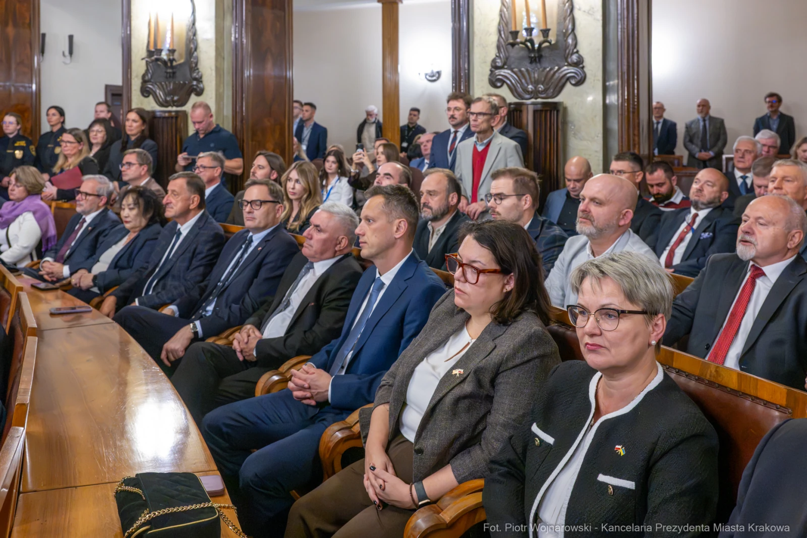Grupa ludzi w sali obrad, wśród nich urzędnicy i goście, w trakcie spotkania.  Autor: Piotr Wojnarowski