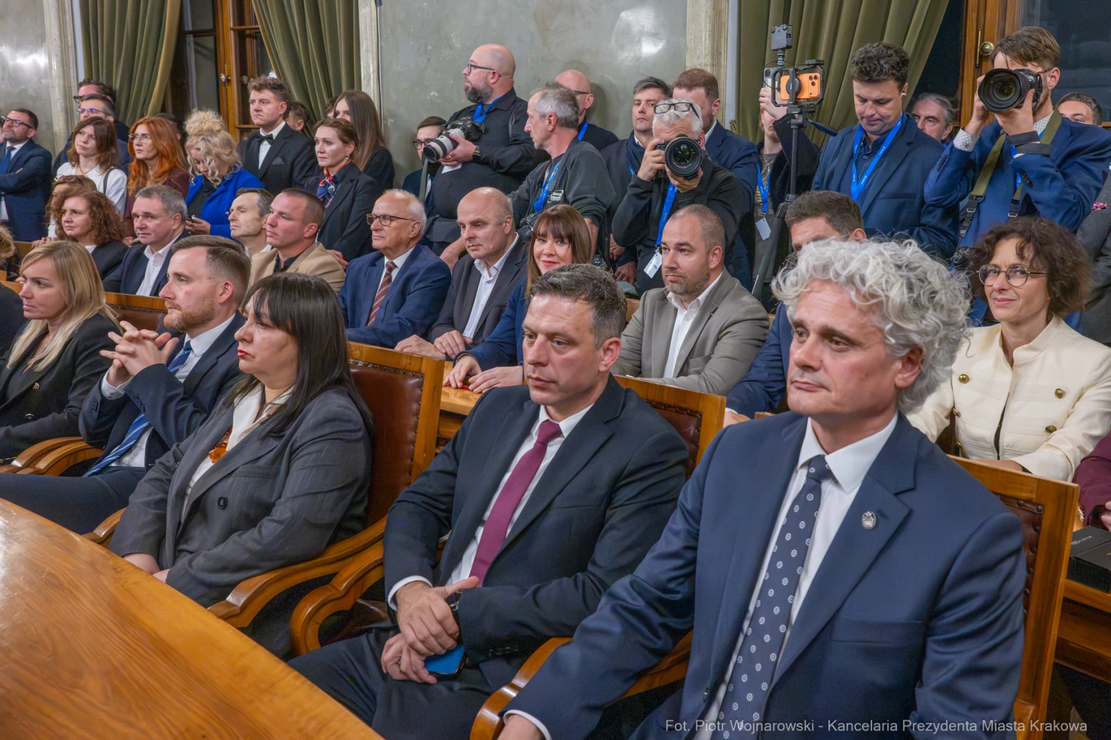 Grupa ludzi w sali obrad, niektórzy z nich w garniturach, inni w formalnych strojach.  Autor: Piotr Wojnarowski