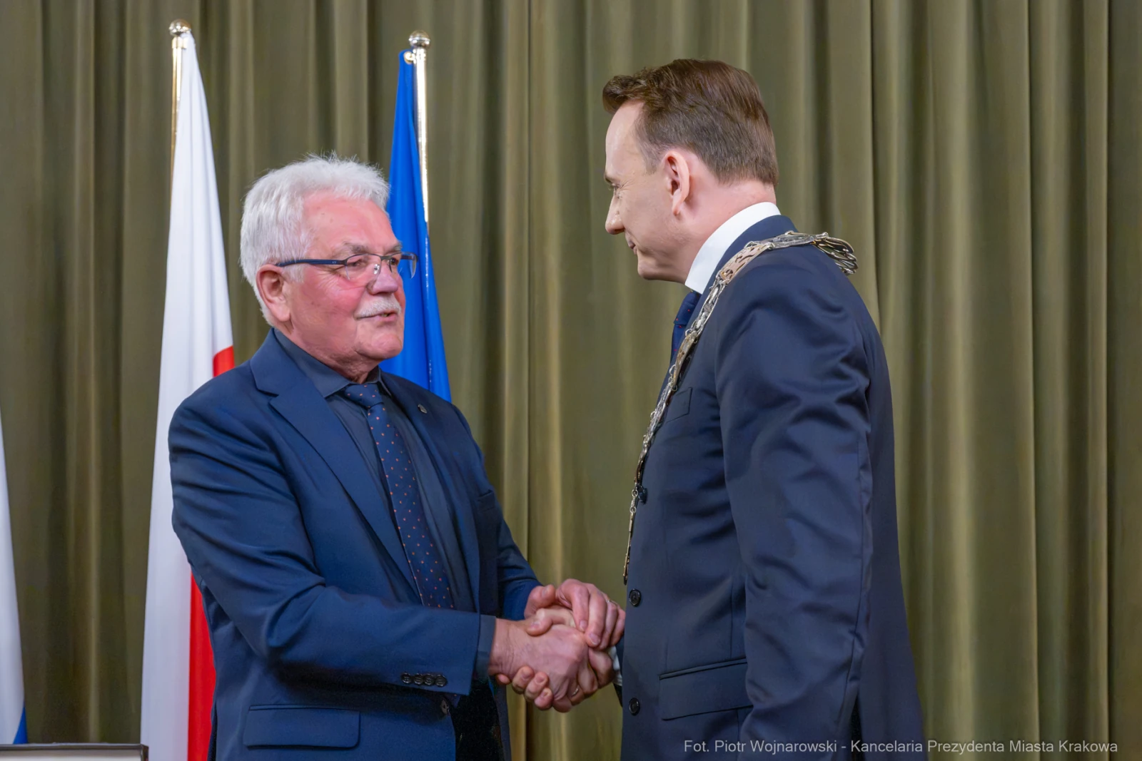 Dwaj mężczyźni uścisnęli sobie dłonie podczas ceremonii wręczenia odznaczeń.  Autor: Piotr Wojnarowski