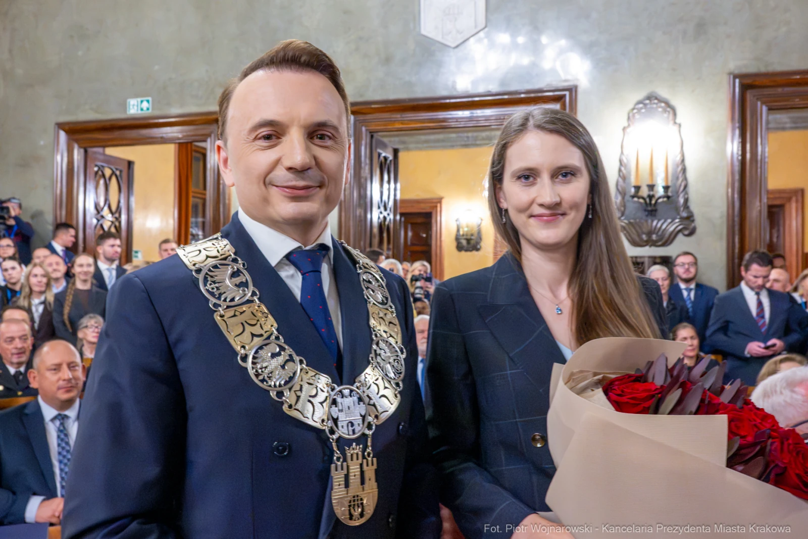 Mężczyzna w łańcuchu prezydenckim i kobieta z bukietem róż podczas uroczystości.  Autor: Piotr Wojnarowski