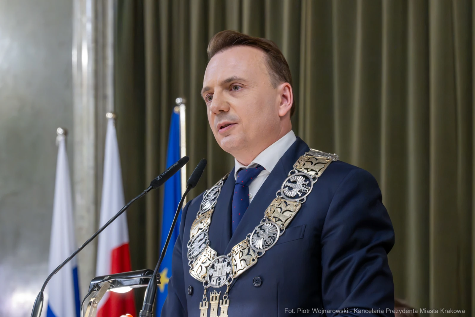 Mężczyzna w garniturze z łańcuchem prezydenckim przemawia do zgromadzenia.  Autor: Piotr Wojnarowski