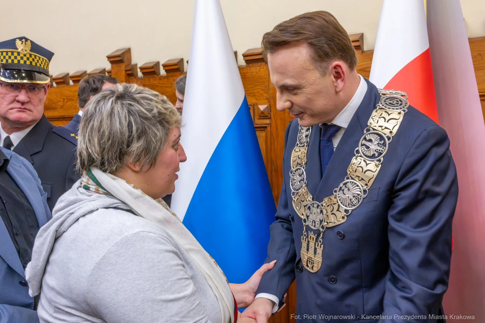 Spotkanie z przedstawicielem władz, rozmowa z kobietą, flagi Polski i Rosji w tle.  Autor: Piotr Wojnarowski