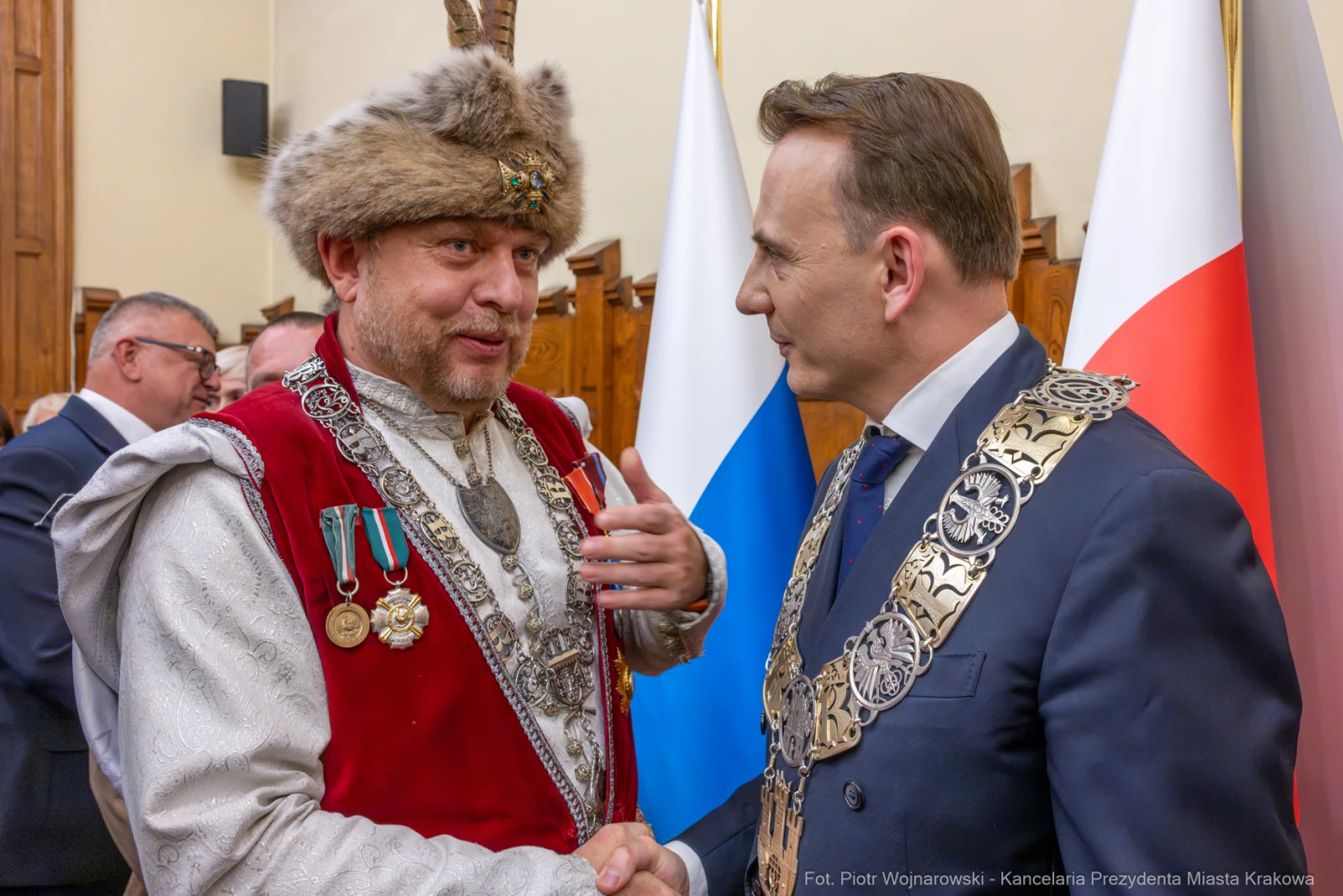 Dwaj mężczyźni w eleganckich strojach rozmawiają, jeden z nich w tradycyjnym nakryciu głowy.  Autor: Piotr Wojnarowski