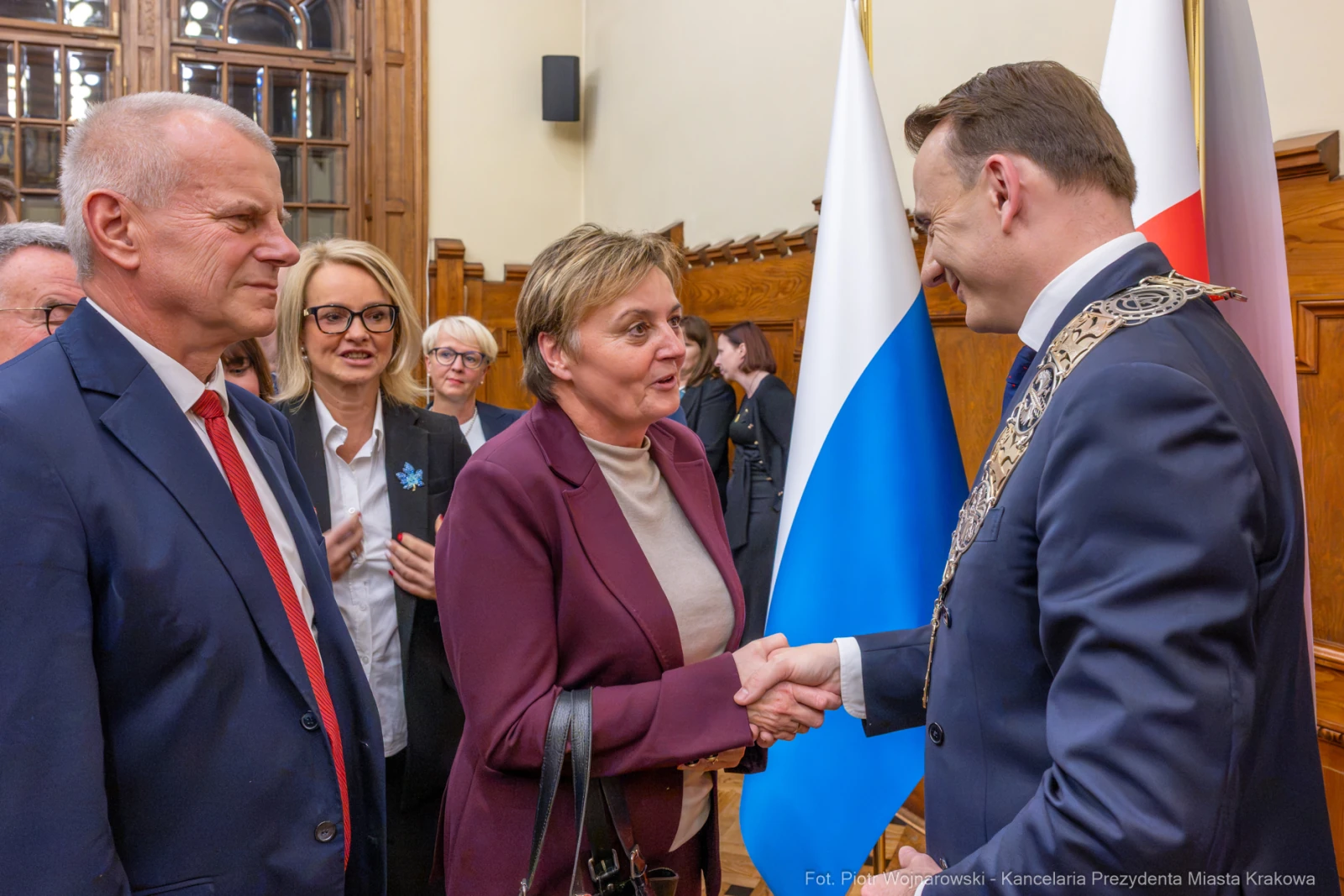 Spotkanie przedstawicieli władz z uściskiem dłoni. Flagi Polski i Krakowa w tle.  Autor: Piotr Wojnarowski