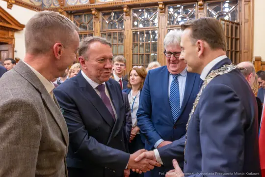 Spotkanie przedstawicieli władz z uśmiechami i uściskami dłoni.