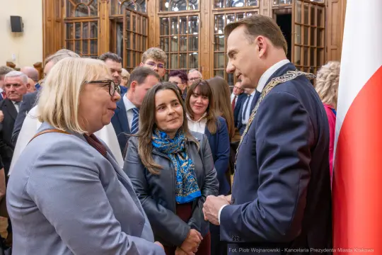 Spotkanie przedstawicieli władz z mieszkańcami, rozmowy w eleganckim wnętrzu.