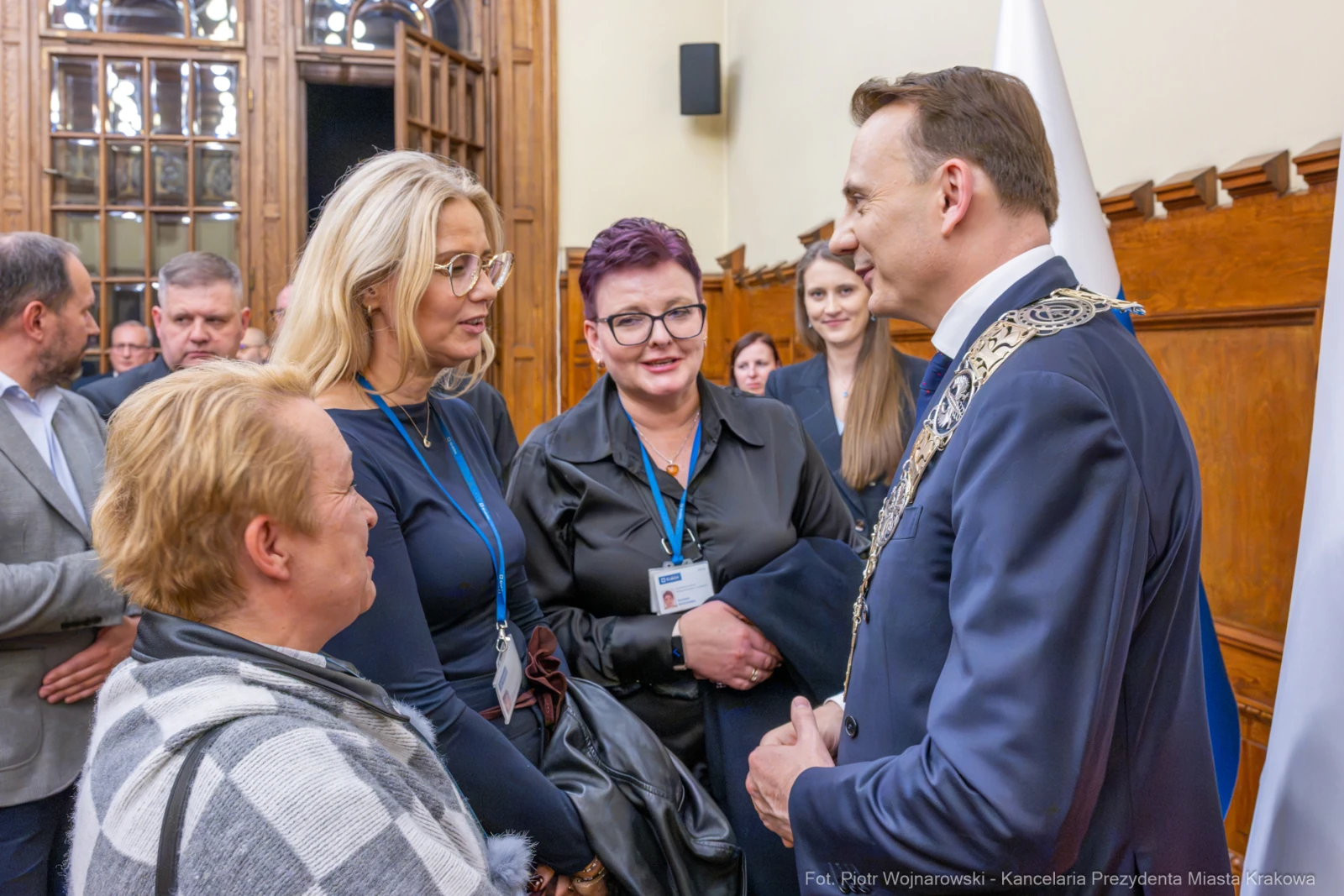 Spotkanie grupy ludzi z mężczyzną w oficjalnym stroju, rozmowy i uśmiechy.  Autor: Piotr Wojnarowski