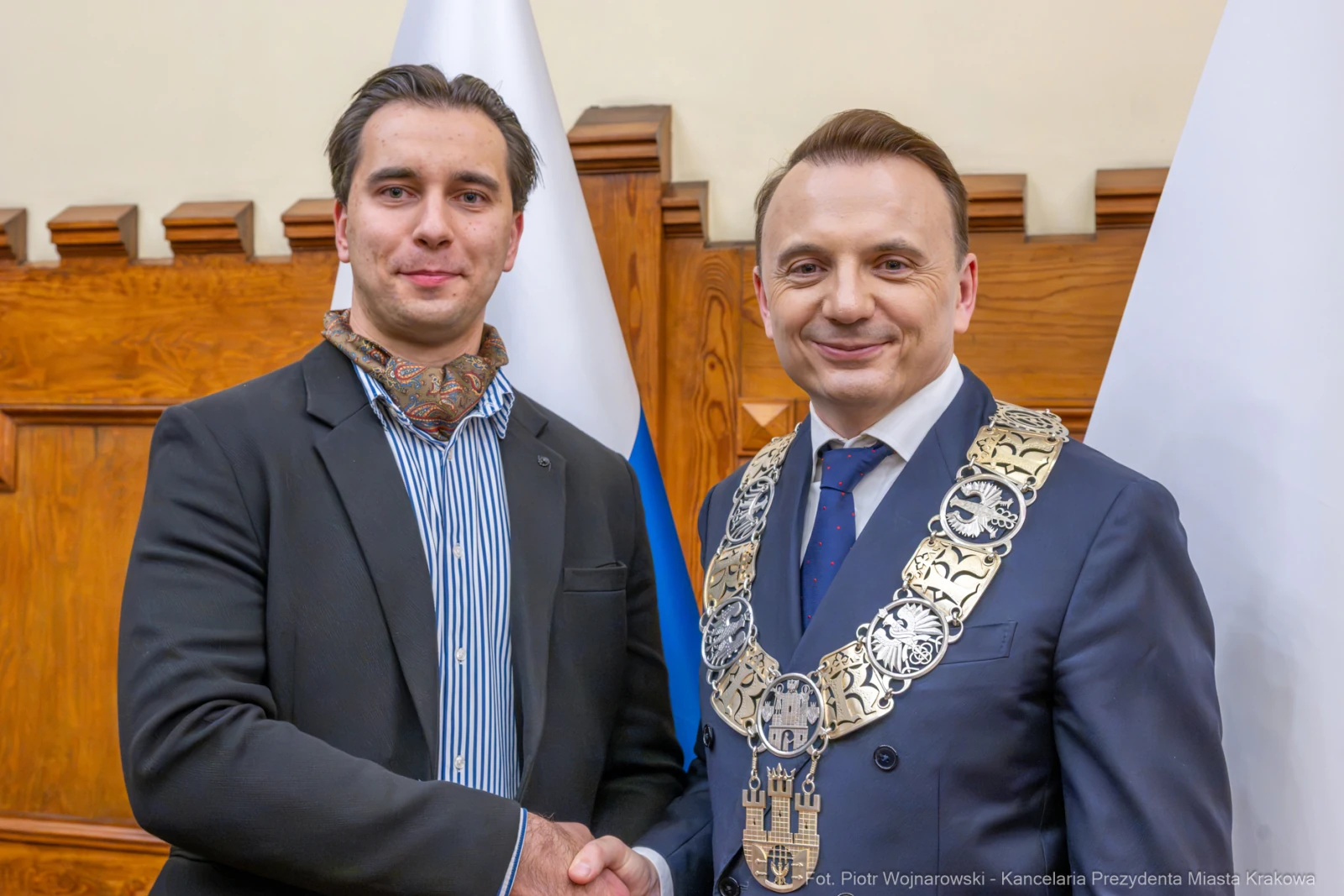 Dwaj mężczyźni w garniturach, jeden z łańcuchem prezydenckim, uściski dłoni. Flagi w tle.  Autor: Piotr Wojnarowski