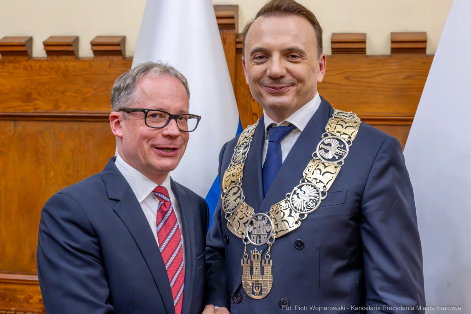 Dwaj mężczyźni w garniturach, jeden z łańcuchem prezydenckim, uściski dłoni.  Autor: Piotr Wojnarowski