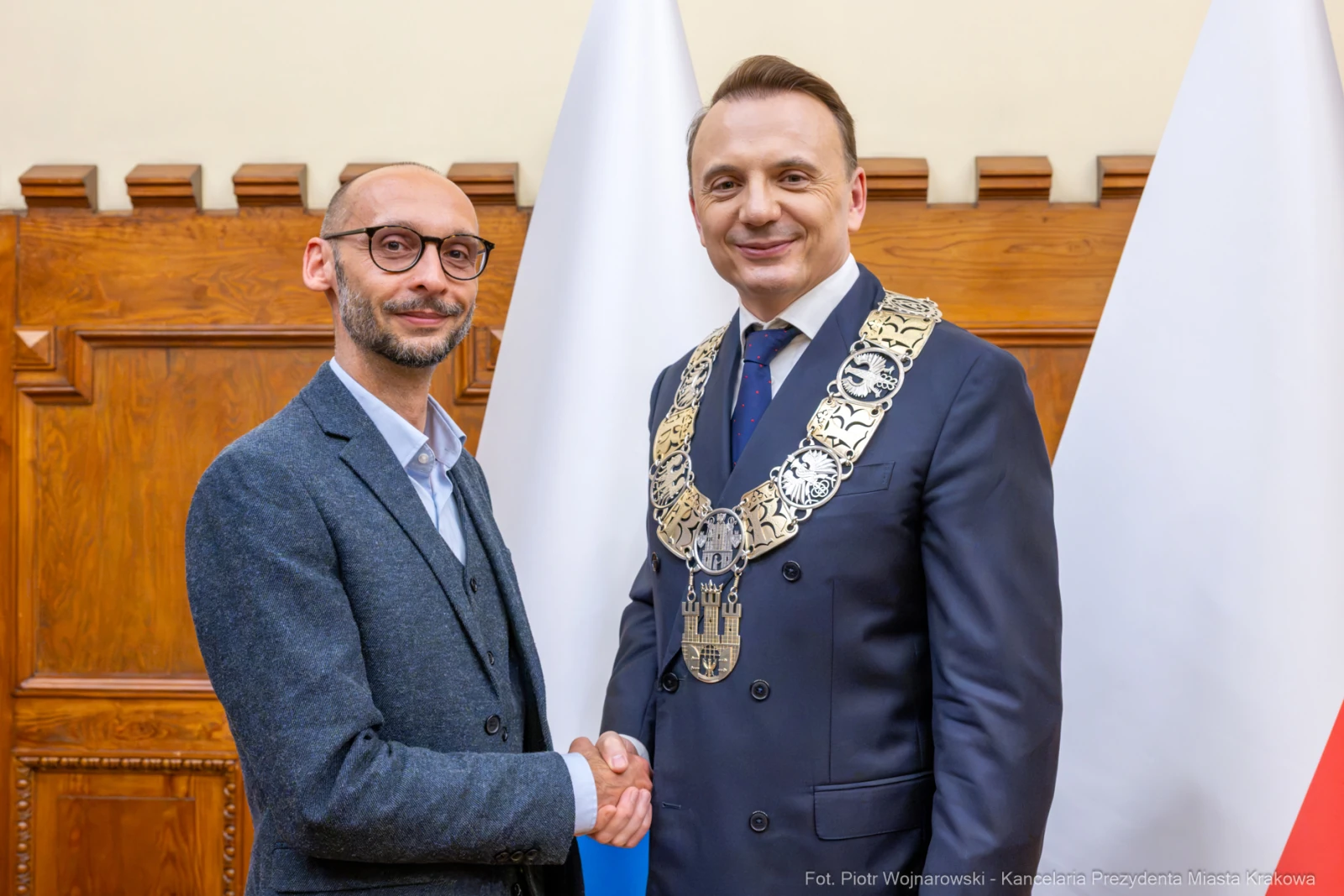 Dwóch mężczyzn w garniturach, jeden z łańcuchem prezydenckim, uściski dłoni.  Autor: Piotr Wojnarowski