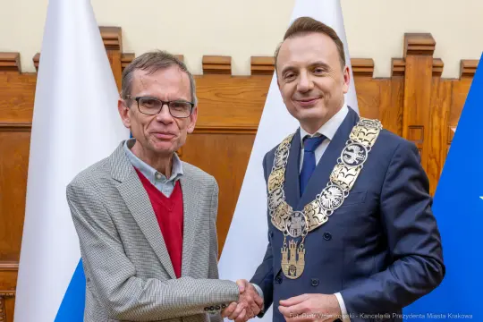 Dwaj mężczyźni uścisnęli sobie dłonie, jeden z nich w łańcuchu prezydenckim.