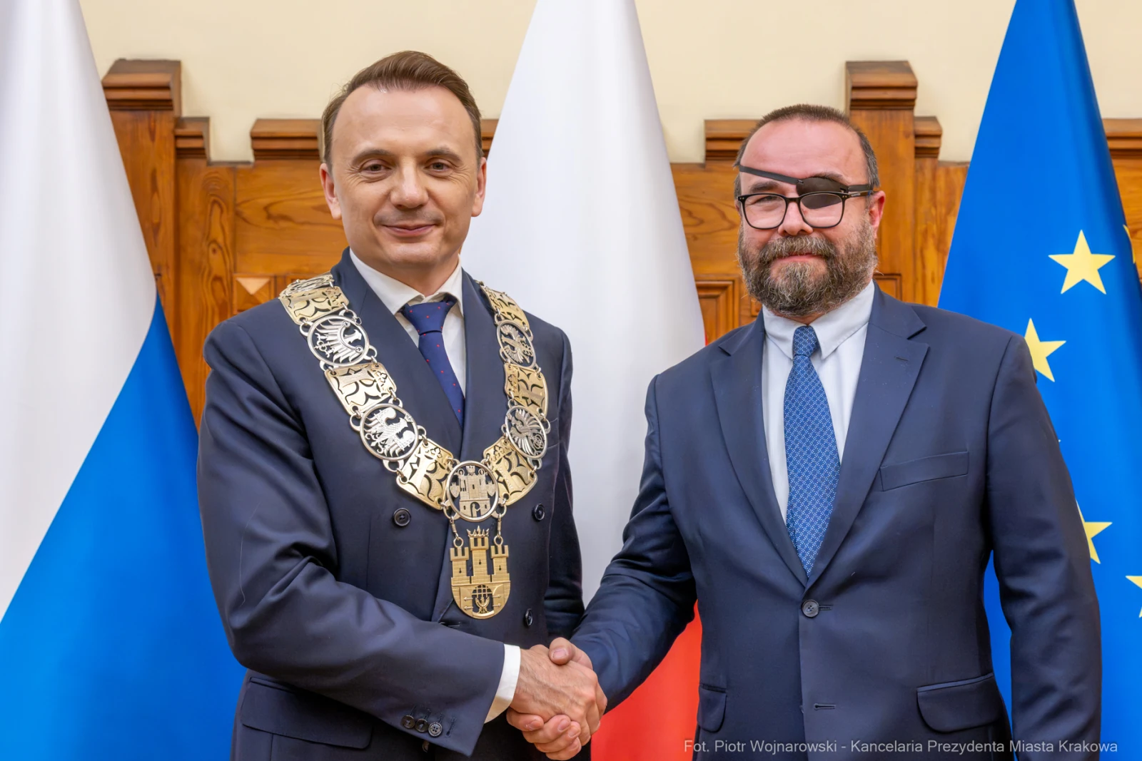 Dwaj mężczyźni w garniturach, jeden z łańcuchem prezydenckim, uściski dłoni. Flagi Polski i Unii Europejskiej  Autor: Piotr Wojnarowski
