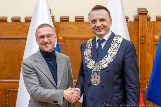Dwaj mężczyźni uścisnęli sobie dłonie, jeden z nich w łańcuchu prezydenckim.