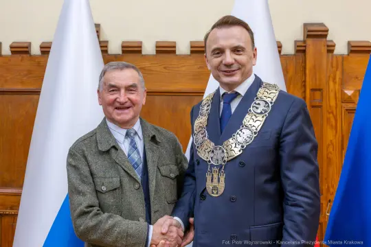 Dwaj mężczyźni uścisnęli sobie dłonie, jeden z nich w łańcuchu prezydenckim.