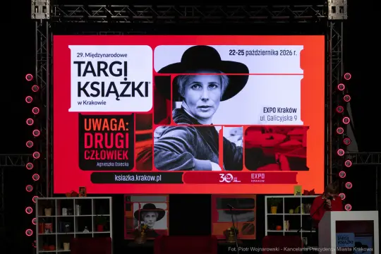 Targi Książki w Krakowie, plakat z informacjami o wydarzeniu i zdjęciem kobiety.