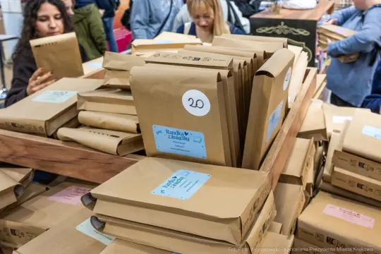 Stos paczek w brązowych kopertach z numerami i etykietami.