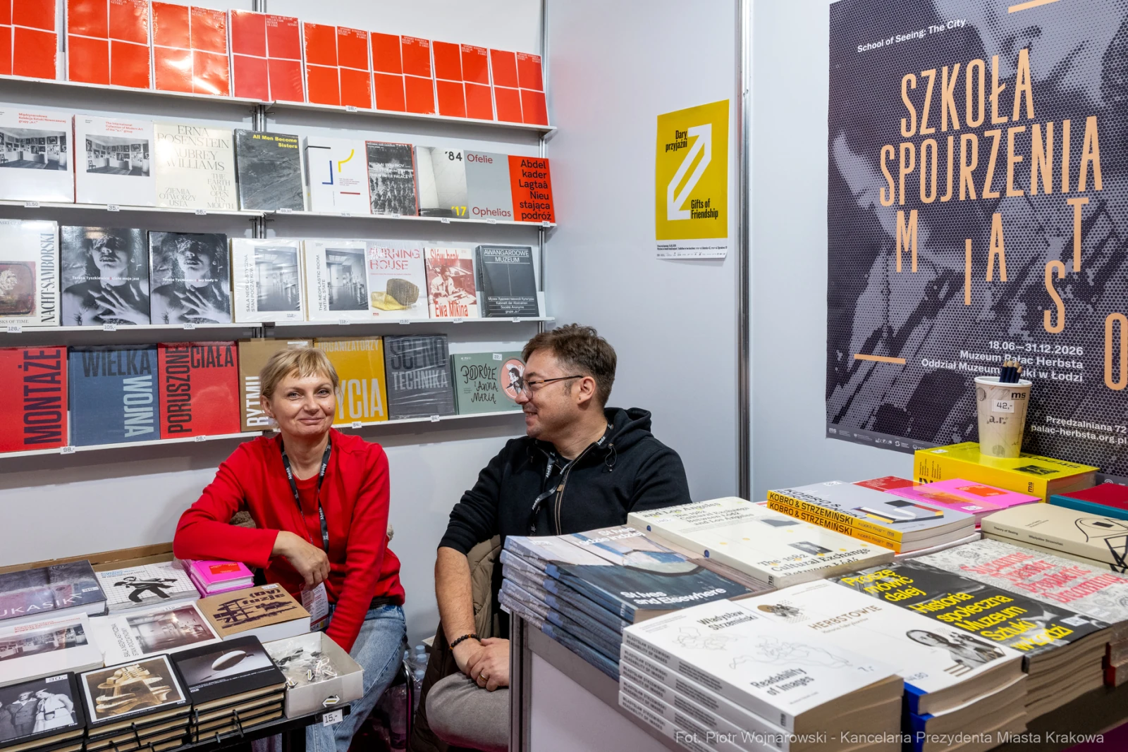 Dwoje ludzi siedzących przy stoisku z książkami na targach.  Autor: Piotr Wojnarowski