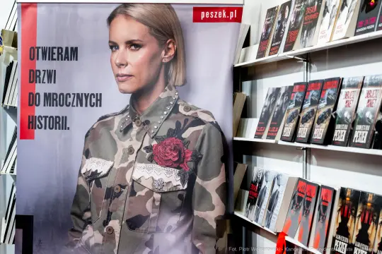 Kobieta w kamuflażowej kurtce z różą, plakat promujący mroczne historie.