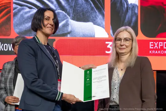 Kobieta odbierająca wyróżnienie podczas ceremonii wręczenia nagród.