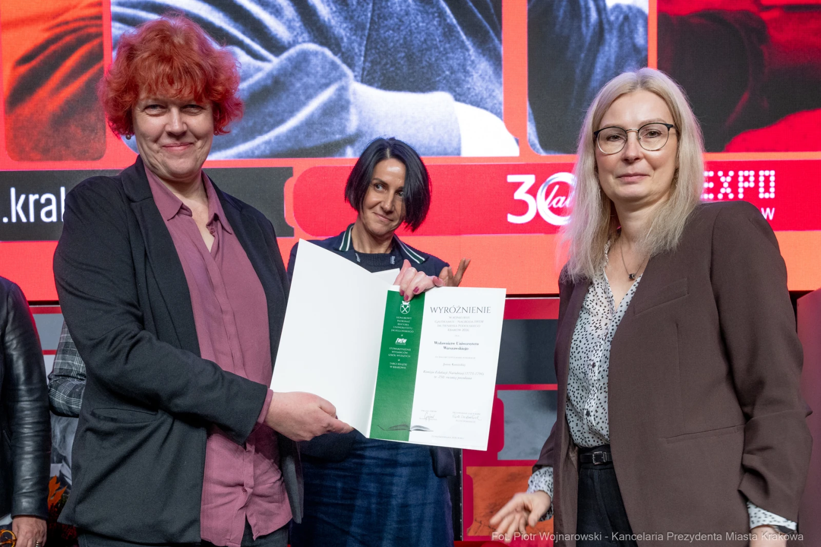 Wręczenie wyróżnienia przez trzy osoby na scenie.  Autor: Piotr Wojnarowski