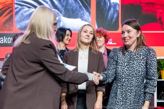 Uczestnicy wydarzenia witają się i wymieniają uściski dłoni.