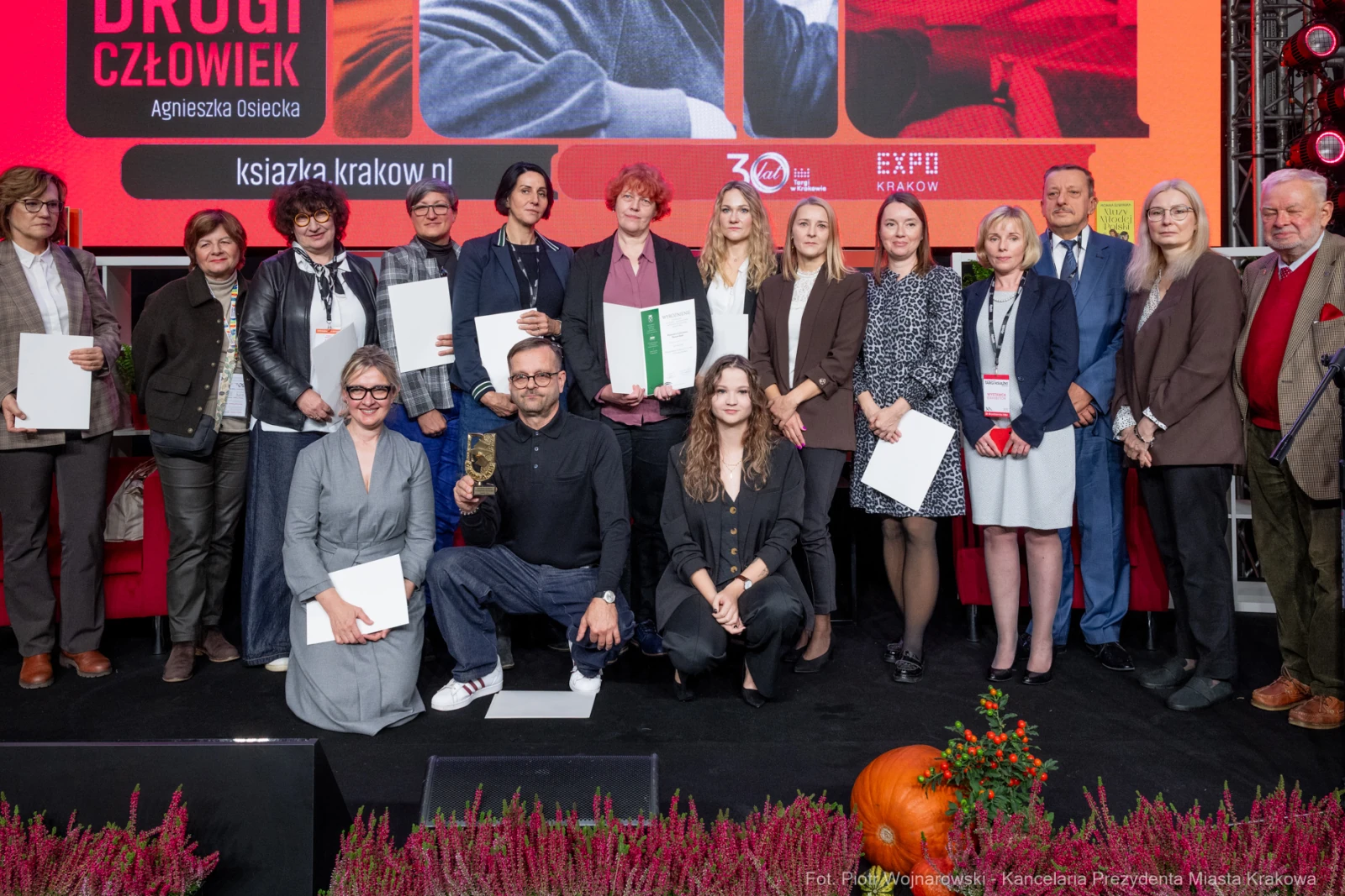 Grupa osób na scenie podczas wydarzenia, trzymających nagrody i dyplomy.  Autor: Piotr Wojnarowski