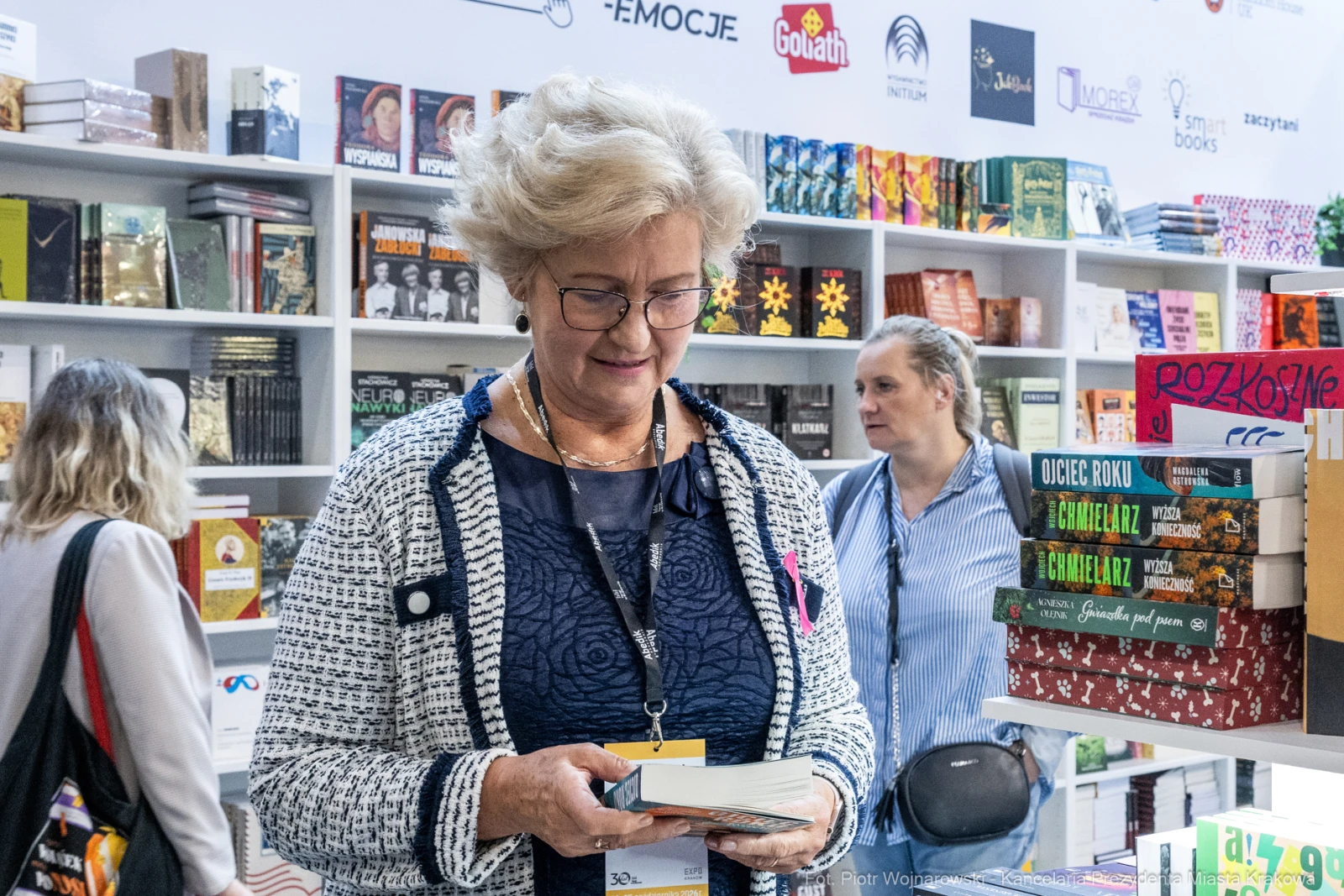 Kobieta przegląda książki w księgarni. W tle widoczne półki z różnymi tytułami.  Autor: Piotr Wojnarowski