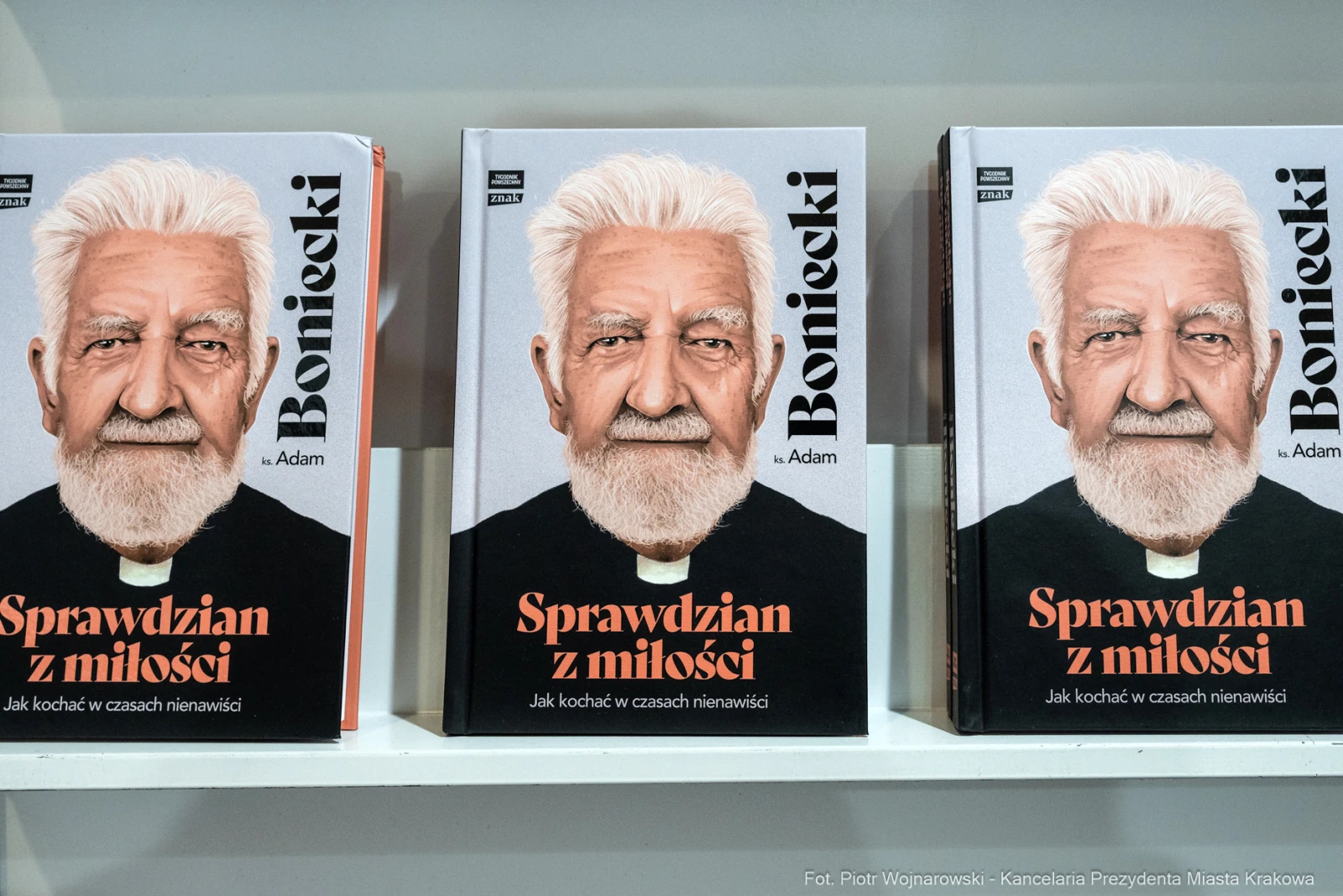 Książki z tytułem Sprawdzian z miłości i portretem starszego mężczyzny z brodą.  Autor: Piotr Wojnarowski