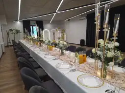 Elegancko udekorowany stół na przyjęcie z kwiatami i świecami.